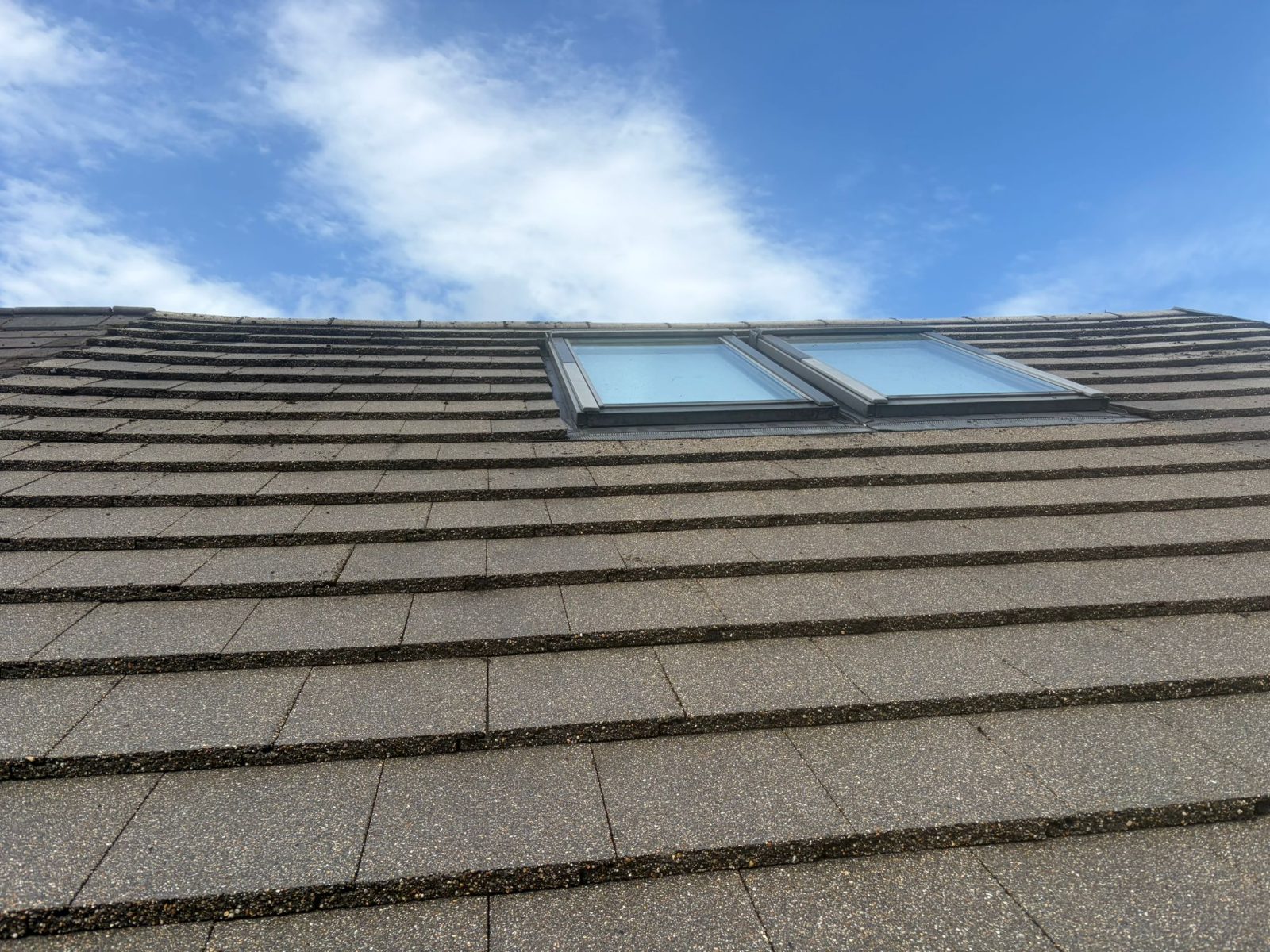 Tiled roof with skylights cleaned against a blue sky
