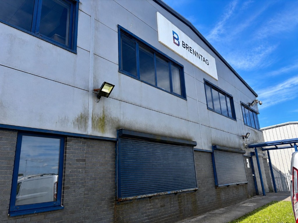 Before: commercial building cladding stained with green algae and dirt
