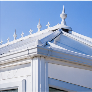 Clean white conservatory roof finials against blue sky
