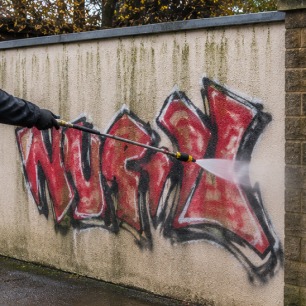 Removing graffiti from a wall with a pressure washer