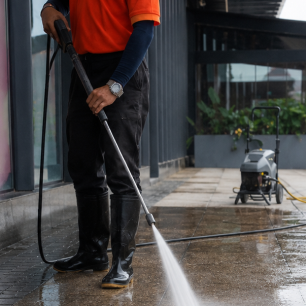 Operator pressure washing a wet patio
